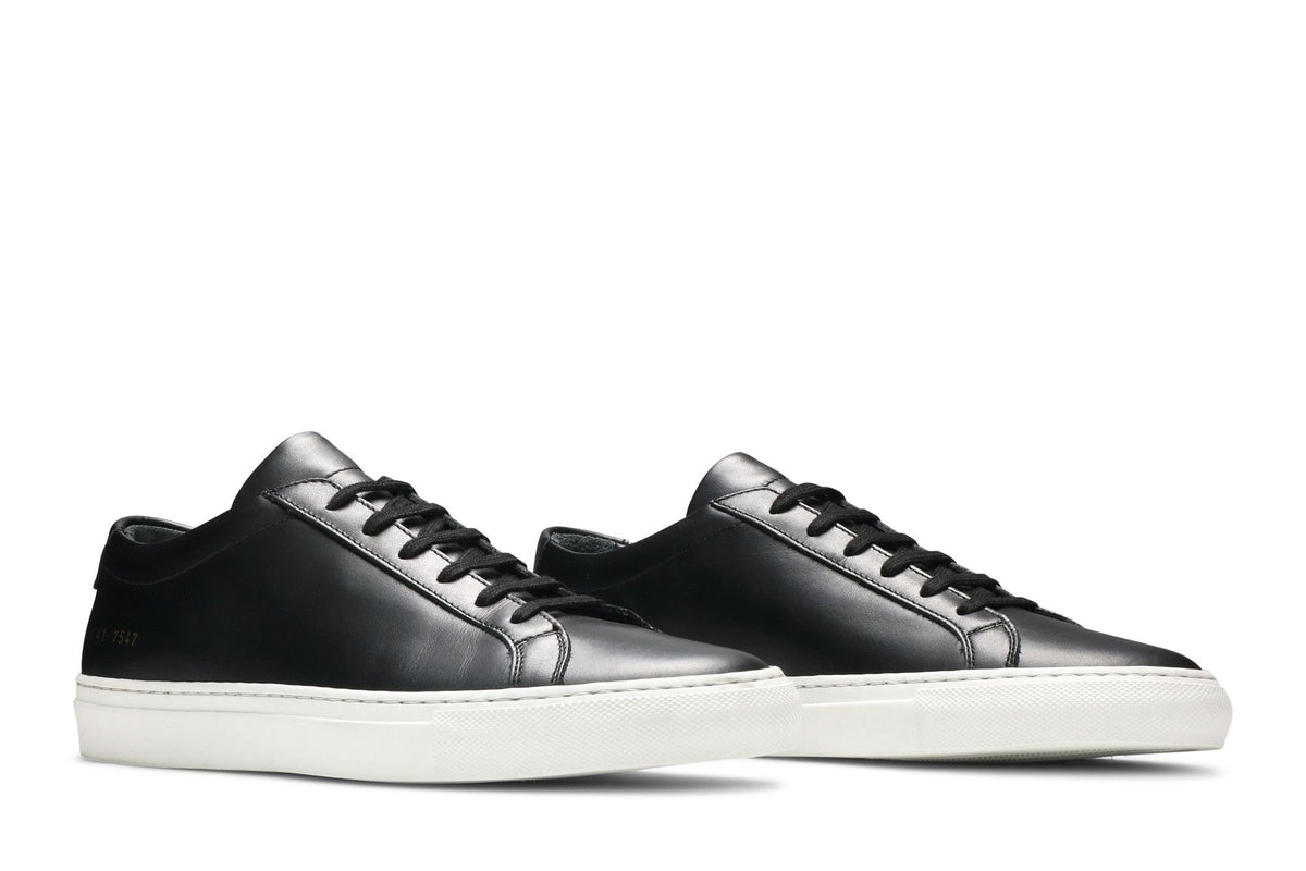 Common Projects Achilles Low Black with white soles, three-quarter view of the pair